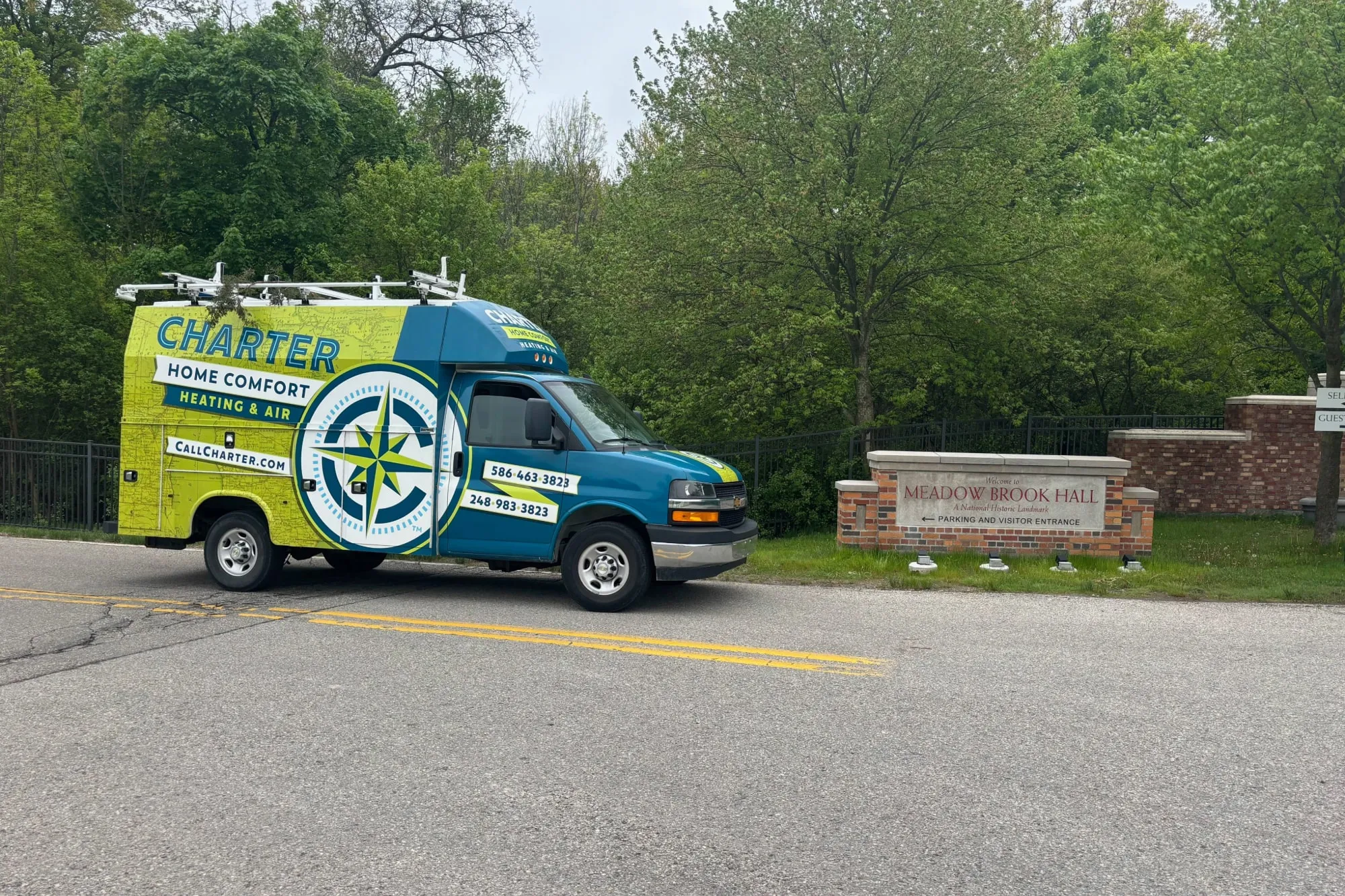 Charter Home Comfort van parked by the entrance to Meadow Brook Hall, a National Historic Landmark located in Rochester Hills, Michigan.   